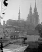 Uppsala domkyrka, Uppsala med byggnadsställningar. I förgrunden Akademikvarnens gård och Fyrisån med Kvarnfallet