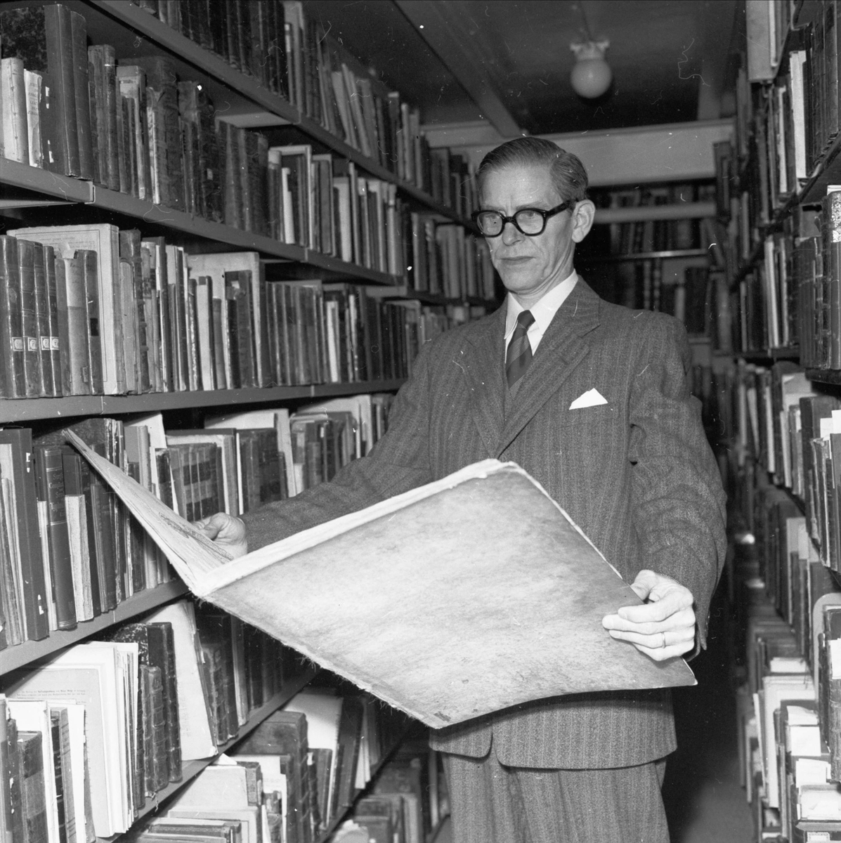 Bibliotekarie Hans Sallander med material ur läkaren Erik Wallers omfattande donation av medicinsk litteratur, handskrifter och brev till Uppsala universitetsbibliotek, Carolina Rediviva, Uppsala 1955