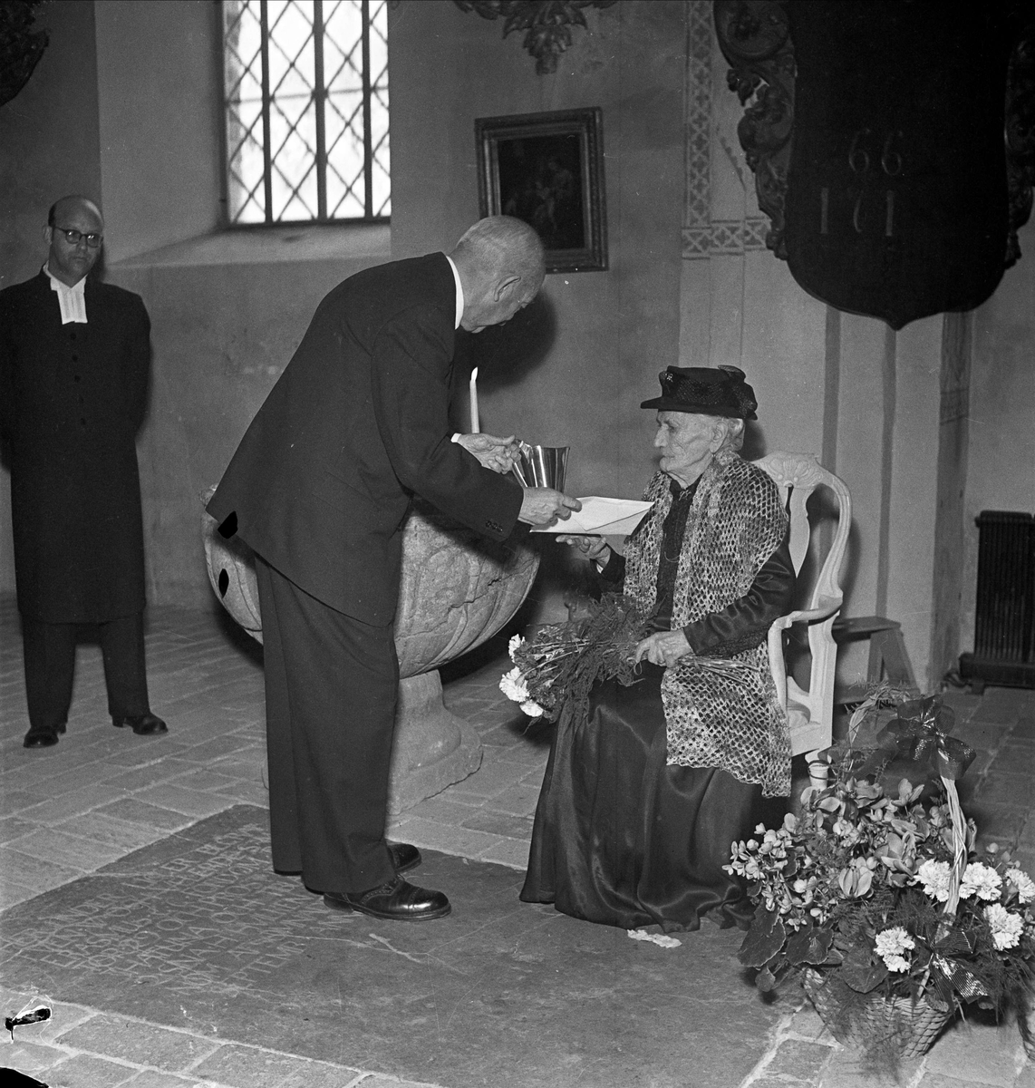 Dop - 100-årig kvinna bär fram sonsonson i Håtuna kyrka, Håtuna socken, Uppland 1954