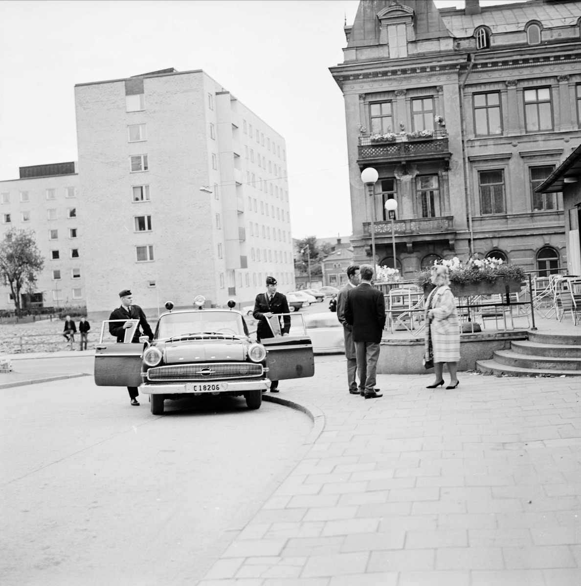 "Lugn' sommarkväll jobbig för radiopolisen" - poliserna Inge Ivarsson och Ove Brunn har stannat vid Uppsala busstation på Kungsgatan för en rutinkontroll, 1964