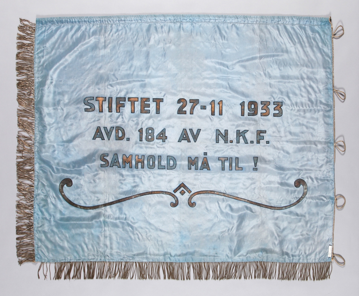 Hovudmotiv: Logo/emblem for NKF (Norsk Kommuneforbund); oppstigande raud sol, lenke i sirkel rundt. Stiliserte liljerrankar på sidene av emblem. Likt på båe sider.