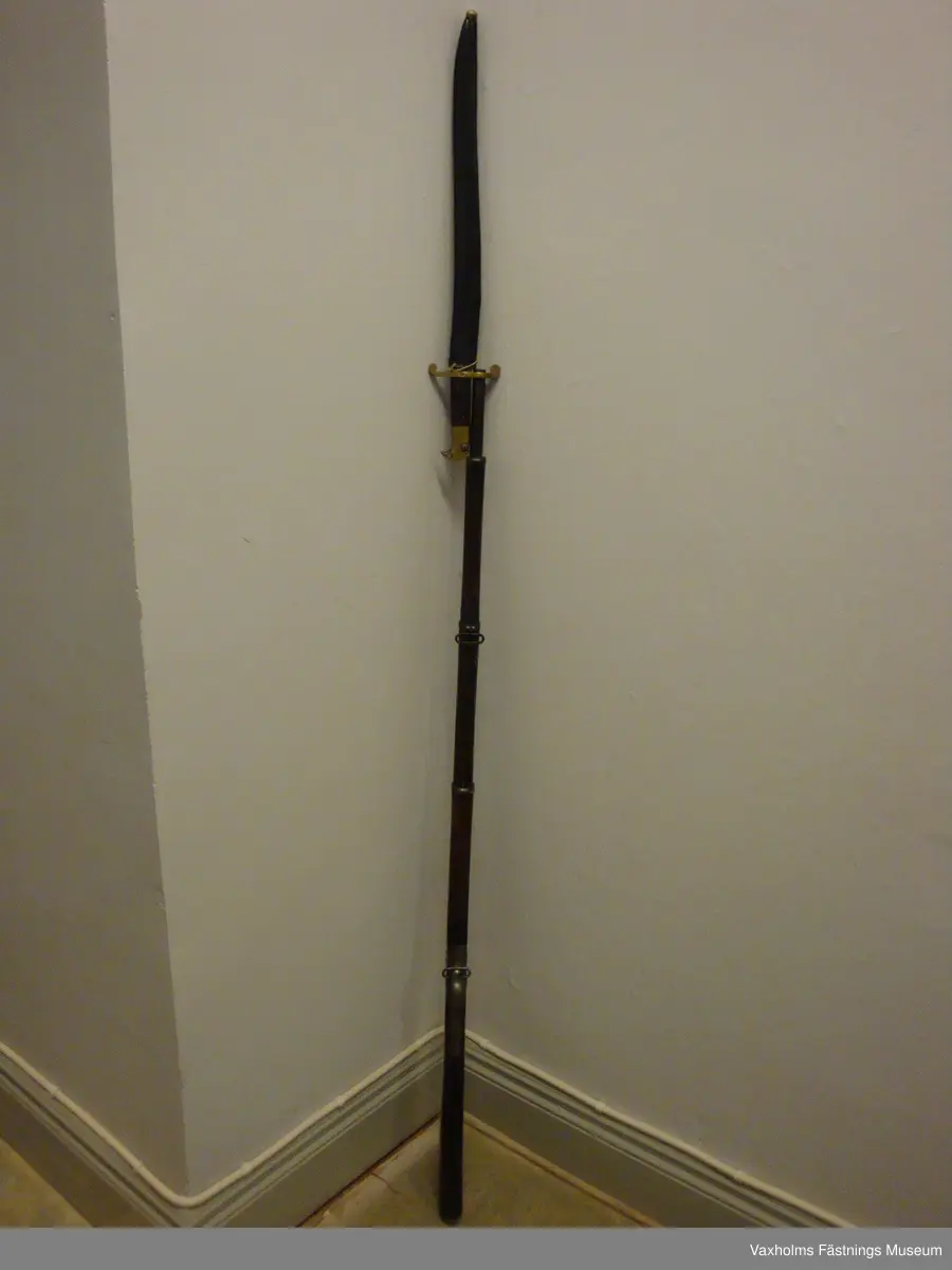 1867 års gevär m/1868 med sabelbajonett och balja.
Stock och kolv med hals i två delar, sammanhållna av mekanismen. Kolvens vinkelsättning mot kärnlinjen stor. Mörkbrunbetsad. Bakplan insvängt. Beslagen av järn. Näsband och två pipband. Ränna för laddstake som saknas. Pipa rund, avsmalnande mot mynningen, brungjord. 6st refflor. Korn och uppfällbart sikte med skala. Klack för bajonett. Slaghane och stötbotten med krusst grepp. 
I.F. 35d. I.G.I.