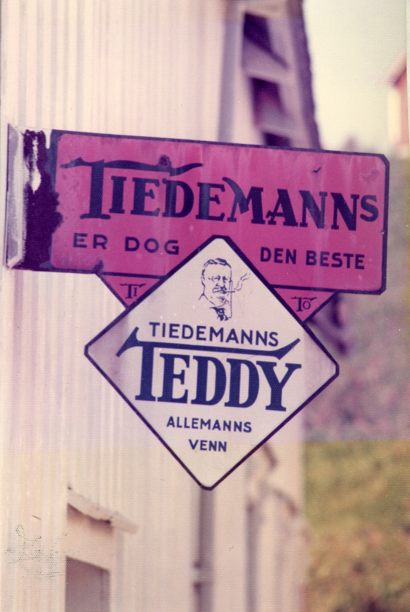 Skilt med reklame for Tiedemanns Teddy sigaretter på fasade.