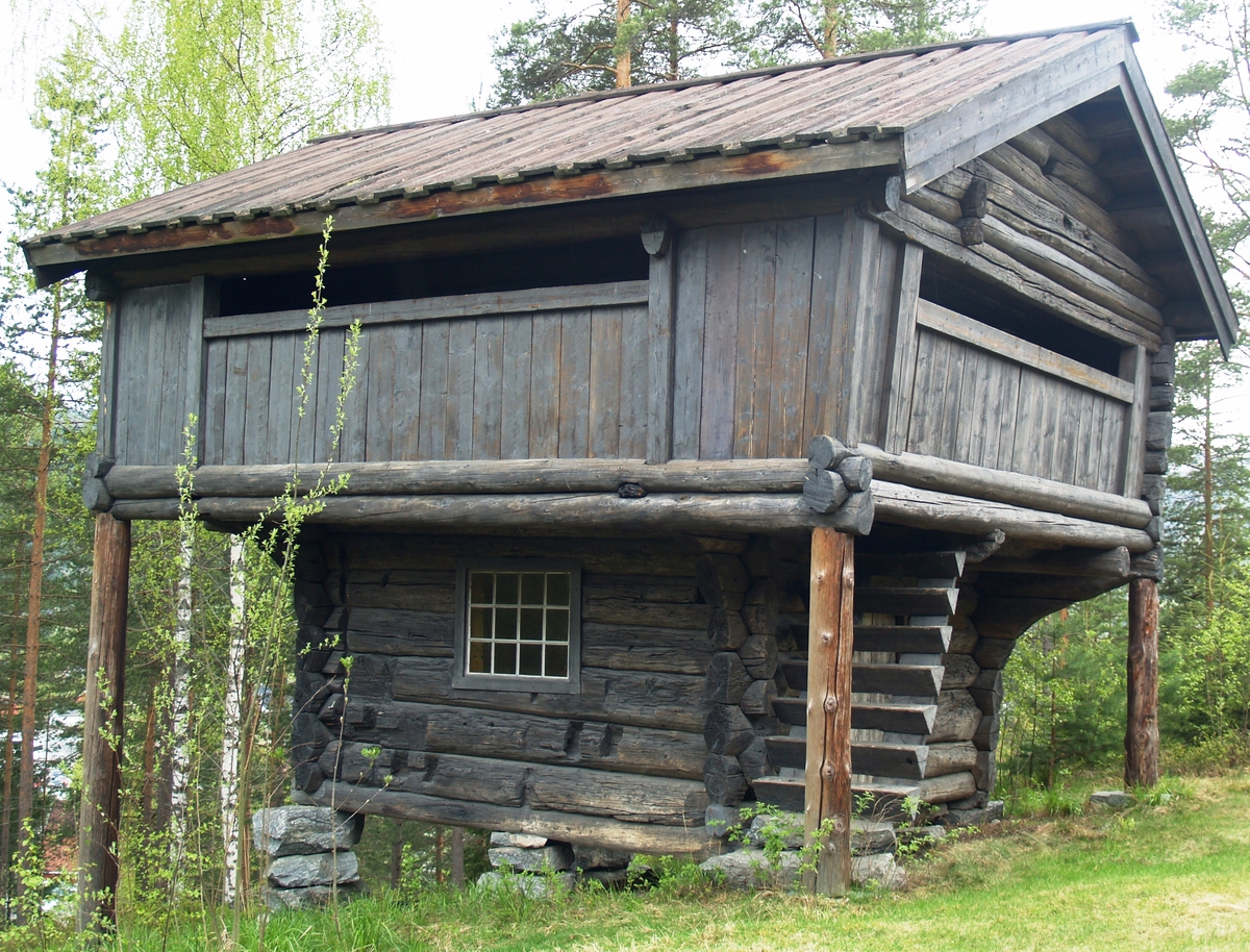 Tømret loft med åpen utkraget svalgang i andre etasje på to av kortsidene og den ene langsiden.