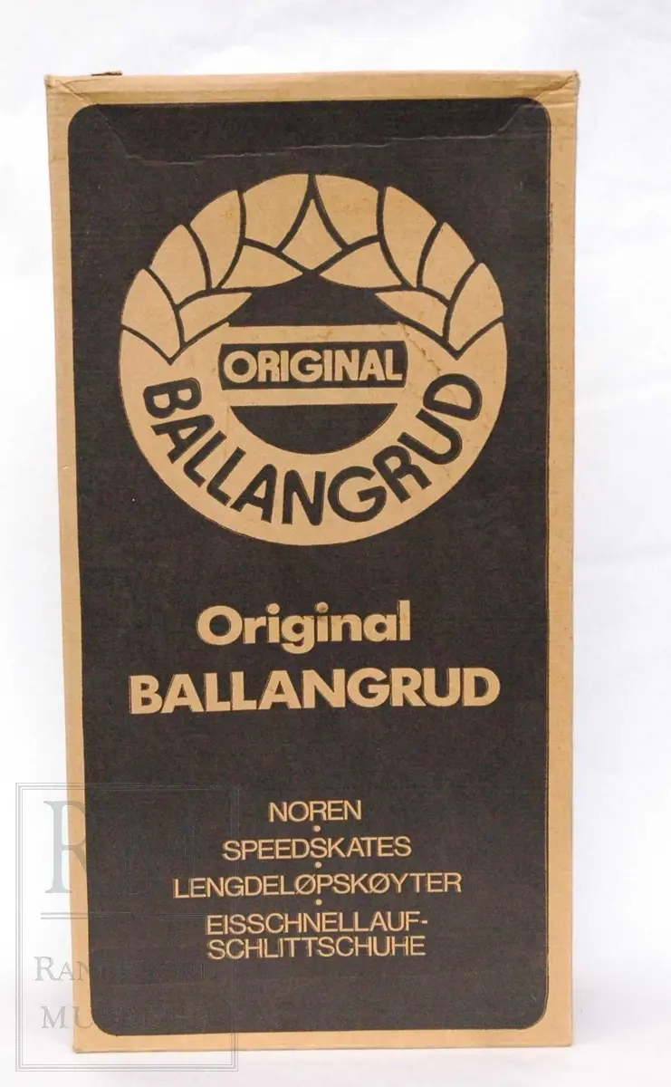 a-b) Skøyter: av svart skinn m / pløse og kant av beige skinn.Røret på skøytejernet avsluttet med plast i begge ender. 
c) plastpose til skøytene.
d) plaststykke.
e-f) Pappeske m/lokk. Brun papp med svart trykk på lokket.
g) pusseklut)
h) skøytefett i tube.