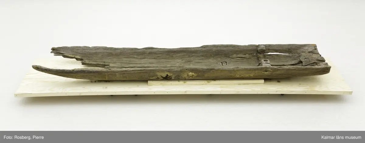 KLM 45167. Båt, stockbåt. Av urholkad trädstam. Huggen i ett stycke. Rektangulärt, något fallande tvärsnitt. Sprucken i fyra delar men de kan lätt sättas samman. I aktern en köl som saknar partier. Kölen sträcker sig fram mot toften, sittbrädan, i båtens akterdel. I toften ett borrat hål. I bottnen på styrbord sida ett hål med en träplugg i, likaså babord reling har ett sådant hål. Fören har blivit lagad vid någon tid och ett stort stycke saknas. I akterns ände tre borrade hål men träpinnar i. Små borrade hål och lagningar med järndobbar, framför allt i fören.