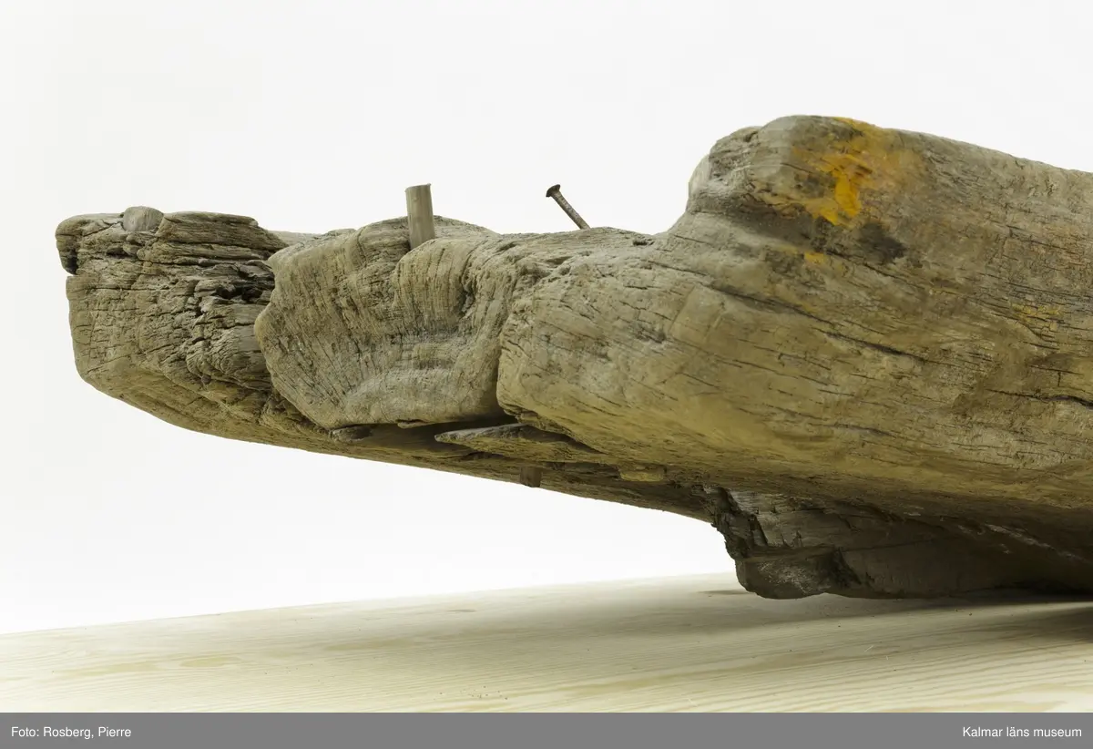 KLM 45167. Båt, stockbåt. Av urholkad trädstam. Huggen i ett stycke. Rektangulärt, något fallande tvärsnitt. Sprucken i fyra delar men de kan lätt sättas samman. I aktern en köl som saknar partier. Kölen sträcker sig fram mot toften, sittbrädan, i båtens akterdel. I toften ett borrat hål. I bottnen på styrbord sida ett hål med en träplugg i, likaså babord reling har ett sådant hål. Fören har blivit lagad vid någon tid och ett stort stycke saknas. I akterns ände tre borrade hål men träpinnar i. Små borrade hål och lagningar med järndobbar, framför allt i fören.