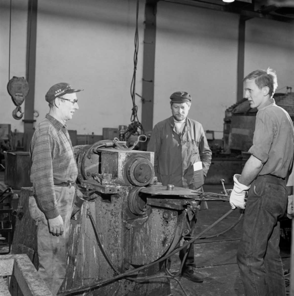 Tre menn ved valsing av rullekniven på Kvernelands Fabrikk AS på Kvernaland: f.v. Stergios Sabalis, Einar Stenberg og Per Gjesdal