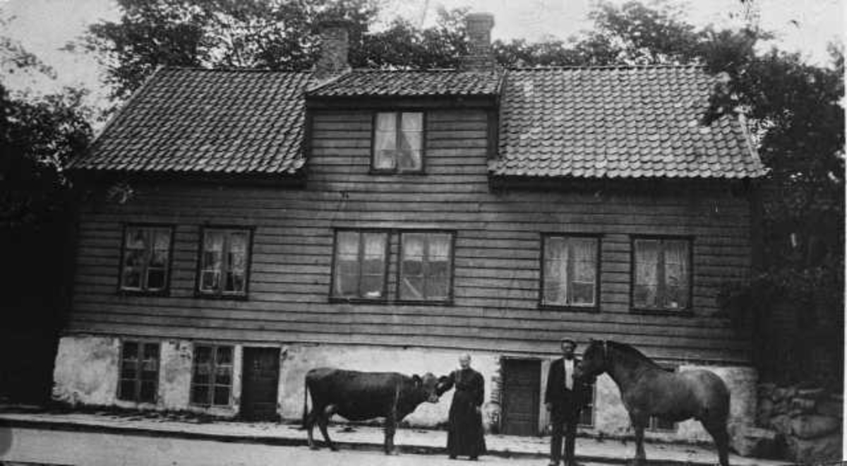 Moulandhuset på Norestraen. Foran: Marie Egelandsdal og sønnen Tellef.

Supplerande/korrigerande opplysningar frå informant:
"Med adresse Strandgt. 76.
Berte Marie Egelandsdal 1844-1930. Sønnen Tellef f. 1875.
Huset står enda - men løftet og påbygget ca. 1931. Kjøpt av Berte Marie, enke etter Torger Egelandsdal (d. 1905) i 1930. 
Bildet er med i Dreyer: Sandnes - bilder fra gamle dager, side 138.
Da Berte Marie døde i 1930 (SA 26/2-1930) at hun har vært sengeliggende i 7 år, har hatt flere slagtilfelle, så bildet må være fra 1905-1923".