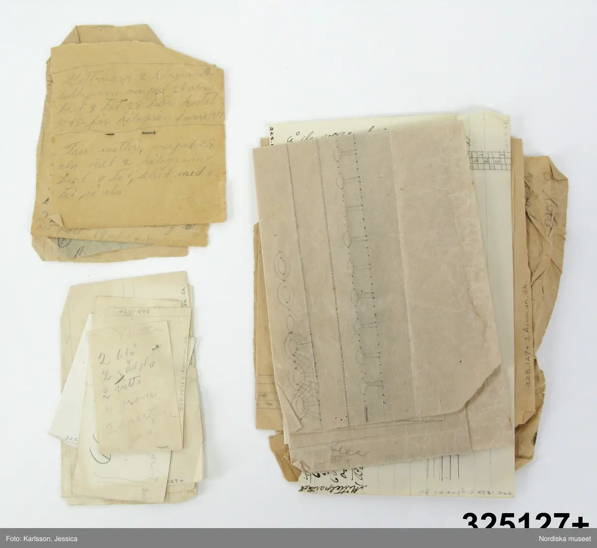 Häfte med blått omslag med etikett på framsidan med tryckt: Mönmsterritningsbok samt påslkrift svagt med blyerts:" Hulda Jönsson, Sandbäck." Tryckt med liten stil: W.H.Nordwall & Co, sjöbo.
Innehåller 26 st 2-mm rutade blad av vilka 15 har anteckningar, solvnotor mm. till vävnader i blyerts och bläck samt färgkrita, bl.a "Gardin nota, Trasmatta, Gardin i myggtjäll, Bomullstyg, Handukar i gåsögon, Handdukar i korndräll, Daldräll, Rosengång, Matta i bomull, Tramatta där varpen bildar fasonerna. Trasmatta med bård på längden." Några verkar avskrivna ur tryckt bok. Dessutom udda mönsterfigurer bl.a opphämtamönstret till täcke/duk inv.nr 325137.
Anm. Fläck på baksidan.
Två tygprover, ett löst 7 x 6,5 cm, och ett fäst med knappnål 11 x 5 cm, båda vävda i gles tuskaft med tunt tvinnat vitt bomullsgarn. Dessutom 13 lösa papperslappar i olika storlek och sort varav några hopfästa med knappnålar. Med anteckningar, solvnotor mm. till vävnader och även ett knyppelmönster till en uddspets.
Hulda Jönsson var född 1885 i S. Åsums sn, dotter till statdrängen Jöns persson, arbetade som piga på en gård i Sandbäck i S.Åsum, där hon lärde sig väva. På 1920-talet vävde hon på beställning åt privatpersoner och Hemkultur i Malmö, från 1930 trasmattor som såldes genom "Kooperativa i Sjöbo". Se textilier och vävböcker inv.nr 325 125 - 137.
Se vidare bilaga och D.408
/Ingrid Frankow 1999/
/Berit Eldvik 2011-03-02