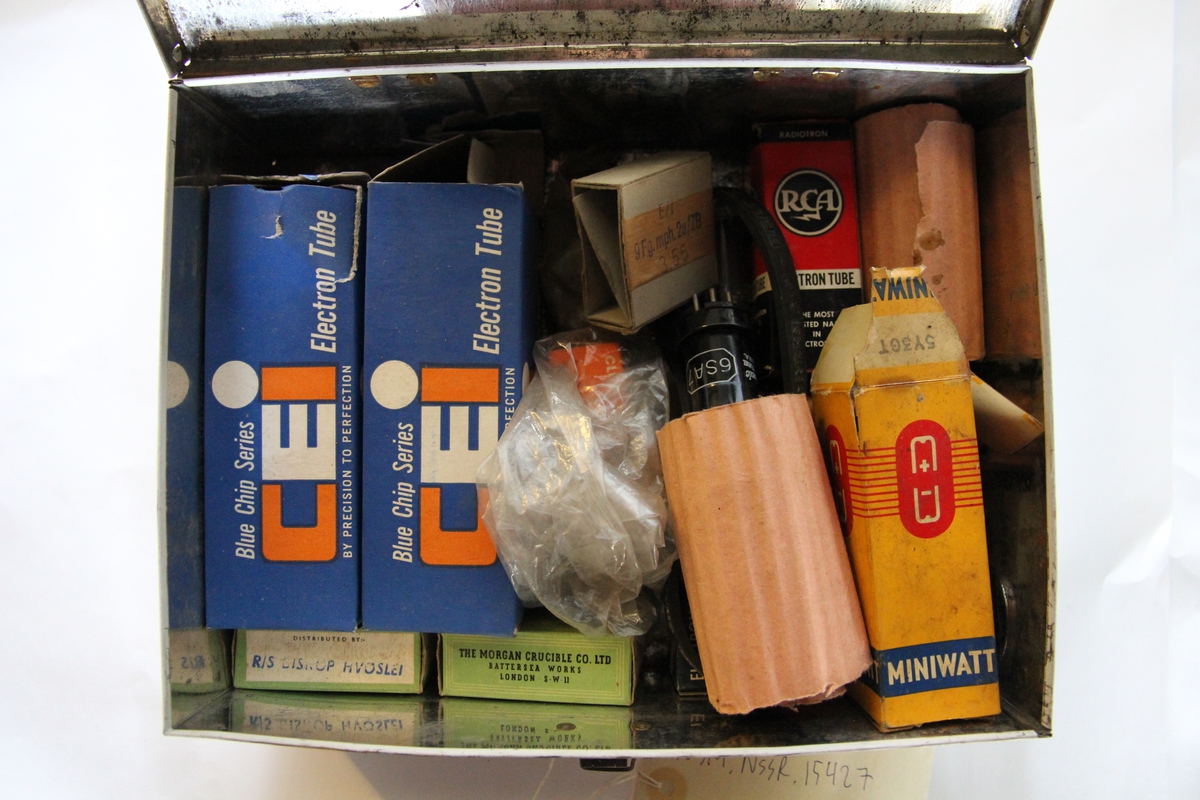 Boks av blikk innholdene diverse reservedeler til radiotelefon.