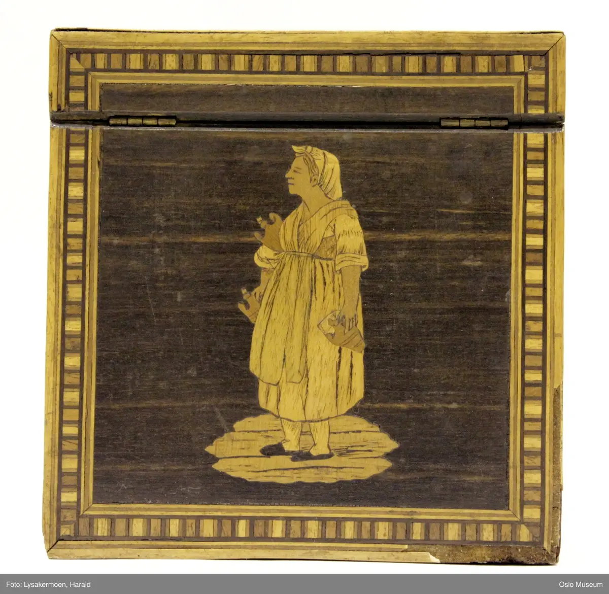 Alle fire sider og lokk har innlagte motiver i gullfargede og brune sjatteringer. (Se foto).