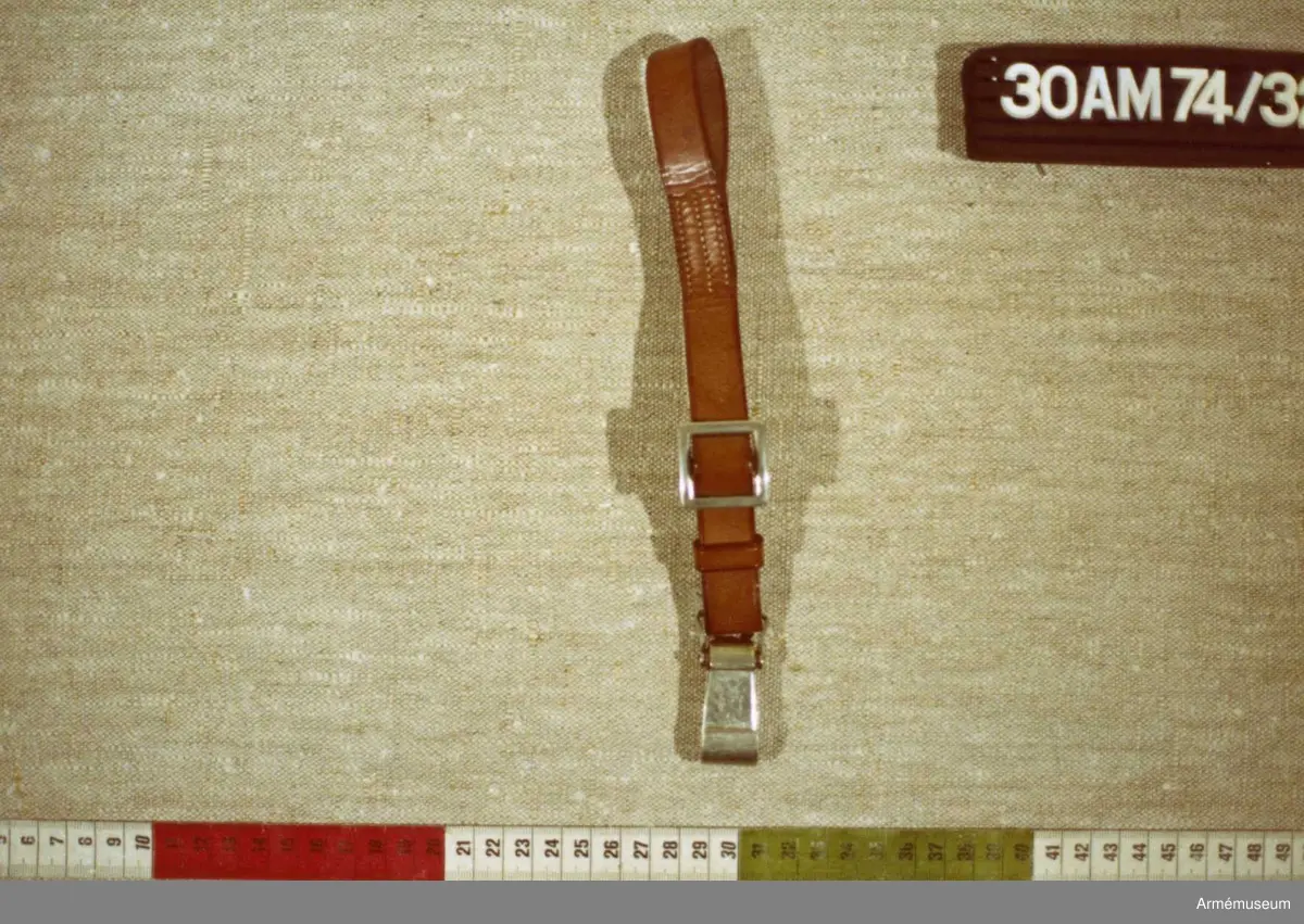 Till livrem m/1939 för officer och underofficer. Remmen är y-formad med ena skänkelns längd: 150 mm. Haken är i mässing.