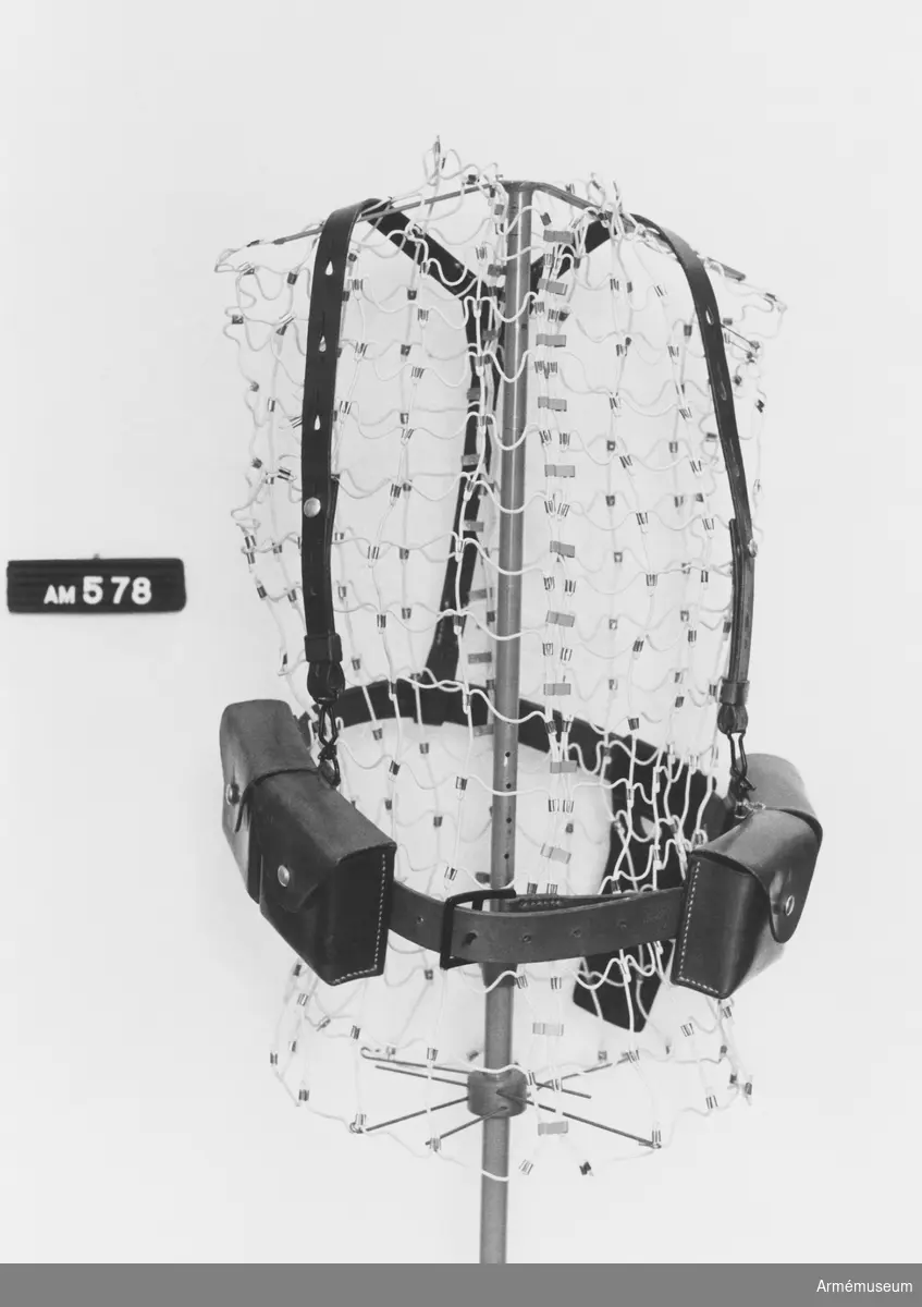 Ammunitionsgördel med hängslen, Schweiz.
Består av: en livrem med fyra patronväskor för gevärsammunition, en hängselanordning, en bajonetthylsa.
Samhörande nr är AM.000511 - AM.000599, AM.000700 - AM.000701.