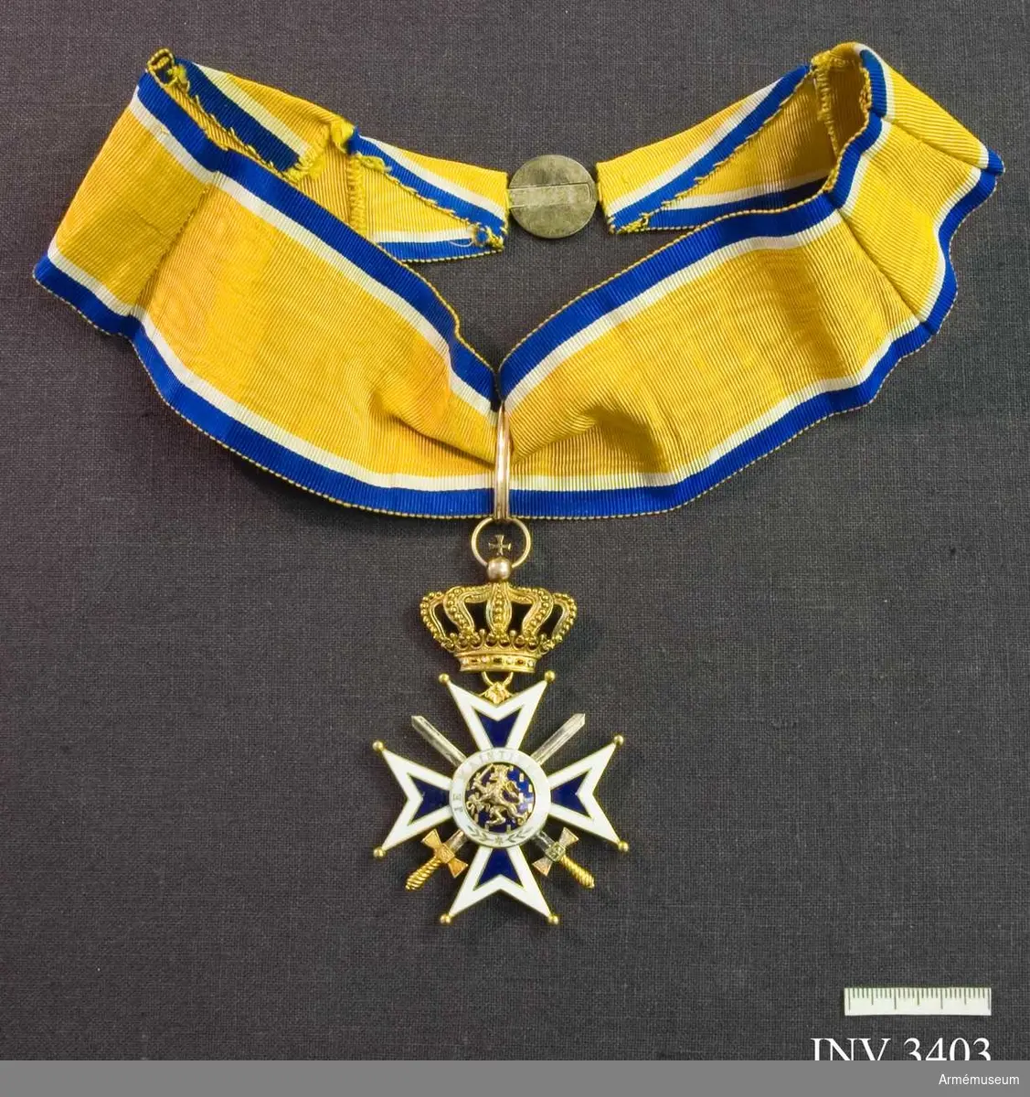 Kommendörstecknet av Nederländska Oranien-Nassau orden m svärd.

I guld och vit och blå emalj. Ordenskorset är ett Georgskors med guldpärlor på spetsarna, ytterkanter av vit emalj och det inre i blå emalj. Två korslagda svärd vilar mellan från och  åtsidan, dessa är i guld. I mitten en blåemaljerad rundel med ett W, krönt med kunglig krona, i mitten, utfört i guld.  Detta är Wilhelminas monogram. (1880-1962). Abdikerade 1948. Runt rundelen ett vitt smaljerat band med i guldskrift: GOD ZY MET ONS (Gud är med oss). 
Frånsidan är utformad på samma  sätt, men i mitten på blåemaljerad botten syns i guld ett  svärdsvingande lejon. På det vita fältet runt lejonet står det: JE  MAINTIENEDRAI (jag vill hålla ut).

Orden hänger i en kunglig krona utförd i guld med runt brämet ädla stenar. Orden hänger i ett gult band  av vattrat siden, med vit och blå kant. Bandet skall knäppas runt halsen.