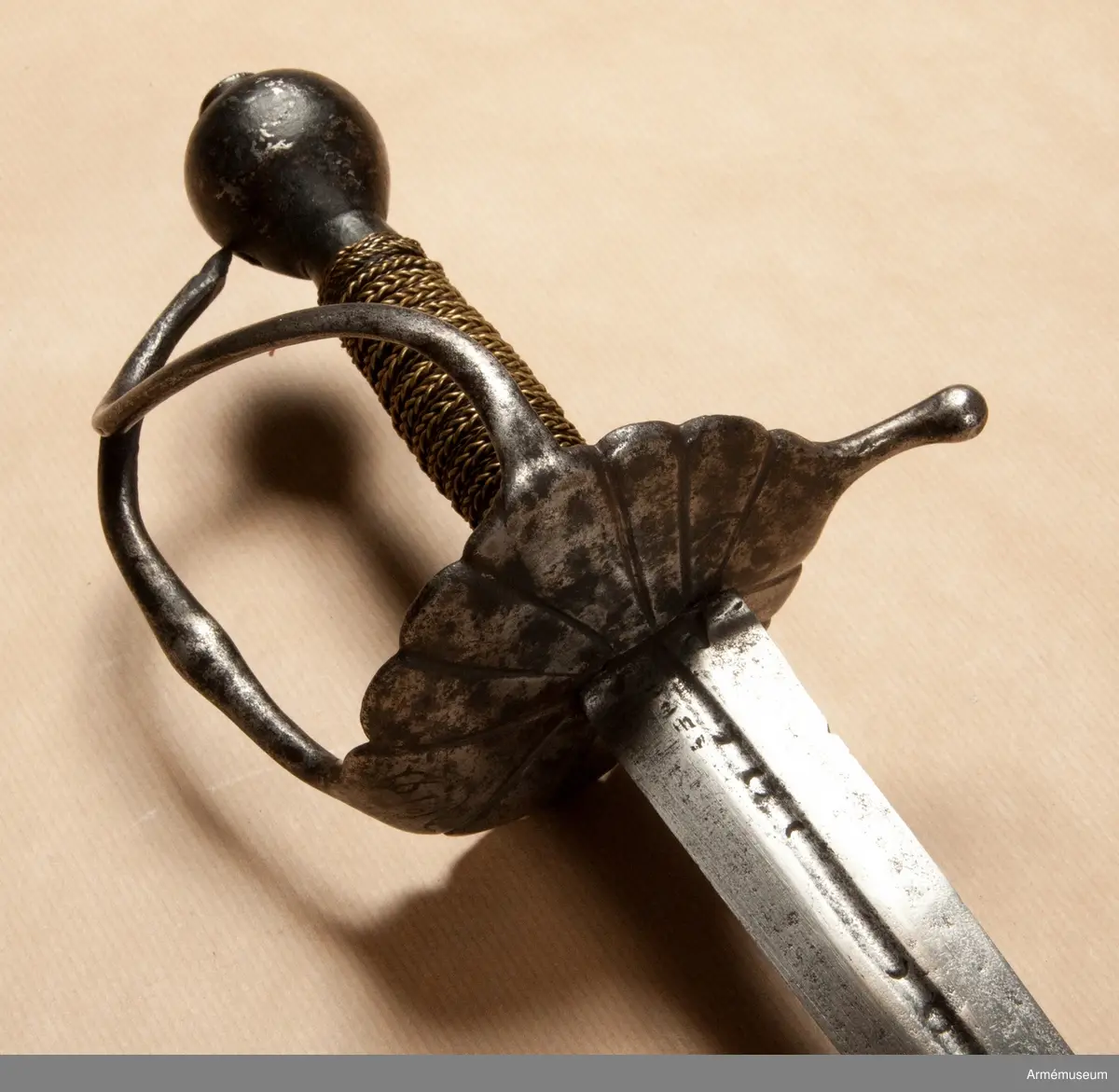 Klingan märkt med P-stämpel och "(CO)". Bredd vid fästet: 34 mm.

Fästet med upp-/nedvänd, äggformig knapp m icke ursprunglig låg nitknapp. Kavellindning av snodda mässingstrådar i reglementsenligt mönster är av senare datum. Randad, flat, svärtad parerplåt; något mindre på insidan än på utsidan. Dess kant är svagt runduddad och den undre sidan har en ornering i form av radialt ordnade ränder. "Nr: 191" inputsat. Handbygeln m förtjockning på mitten är intappad i knappen. Från parerplåten utgår en svängd, yttre sidobygel och ansluter till handbygelns övre del. Parerstången nästan rakt utstående m ett droppformigt avslut. Från parerplåtens insida utgår vertikal tumbygel. 

Klingan tveeggad m flat ås och hålslipning på bägge sidor. I dessa äro inslagna otydliga bokstäver "(CO)" och P-stämpel.