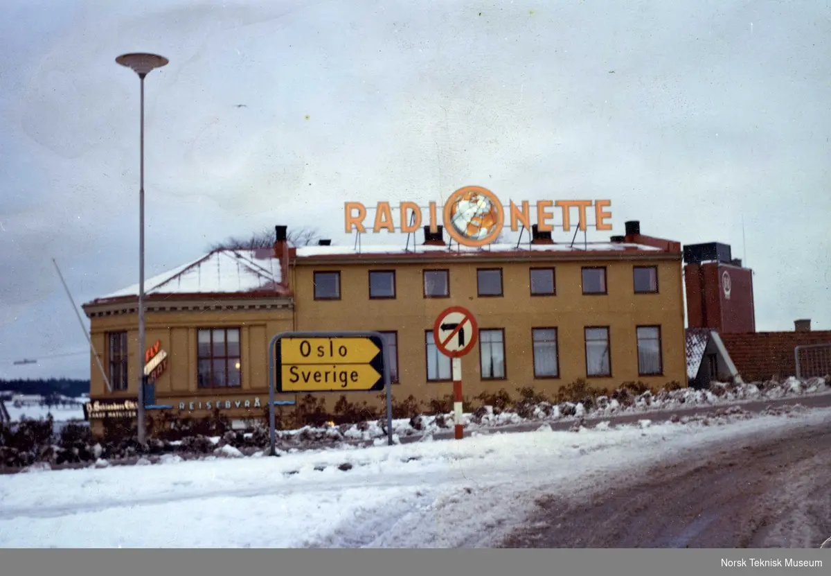 Radionette, lysreklame på hus med veiskilt foran, kanskje Sarpsborg, omkring 1970