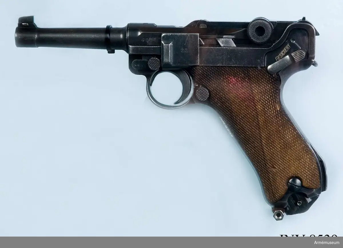 Halvautomatisk pistol, system Borchardt/Luger "Parabellum". Handgrepp av trä. Handgrepp har fäste för löskolv. Märkt S/42 1936 "tysk örn".

8-skotts magasin, märkt fxa p.08 37 (något skadat skick). Samma korn som gevär m/1896 Sverige.