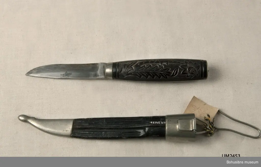 Slidkniv med skaft med graverat floralt mönster. Olika tistelliknande dekorativa ornament.
Slidan har en fästanordning kompletterat med kedja och krok att haka fast förmålet i skärp eller dylikt.

Fabriken flyttar till Sorsakoski, Finland år 1891. Sedan 1870-talets slut har företaget producerat knivar, saxar och skridskor, de s.k. Nurmiskridskorna.

Ur handskrivna katalogen 1957-1958:
Slidkniv m. ornamenterat skaft.
Kniven a) L. 16,8 cm: på bladet: "HACKMAN & Co WIBORG"; svart skaft. Slidan b) L. 15,5; läder m. beslag av metall; kort kedja m. krok. Föremålen hela.

Lappkatalog: 29