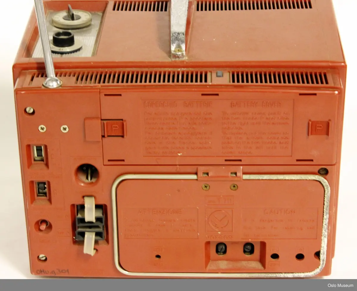 Rektangulær portabel TV med håndtak på toppen, antenne til dra ut bak til høyre og to hjul for frekvens, VHF og UHF på toppen. hull til ledning bak (som mangler). Tre små skruknapper foran for innstilling av lysstyrke, og lyd (ant., samt en av og på knapp for VHF/UHF.