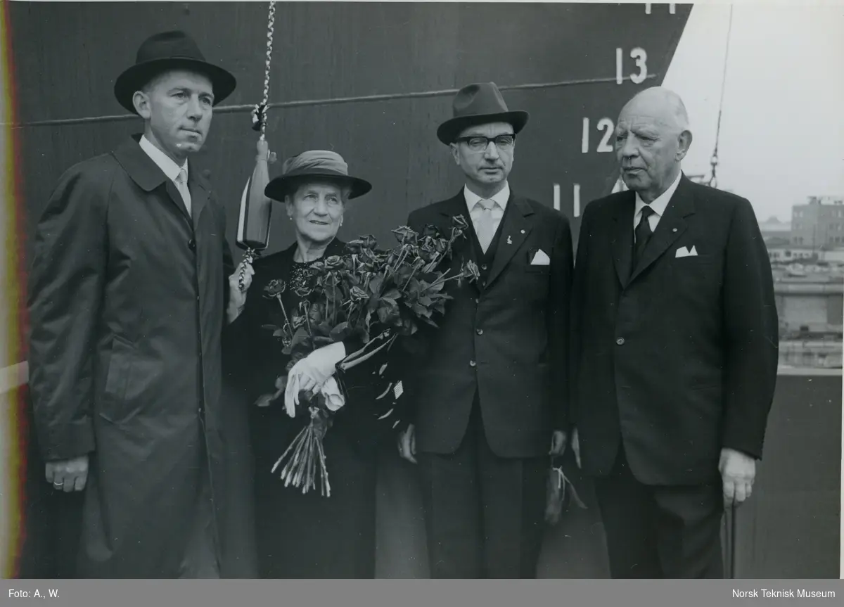 Gudmoren og tre menn på tribunen før dåp og stabelavløpning av passasjerskipet M/S Lofoten, B/N 547 på Akers Mek. Verksted 7. september 1963. Skipet ble levert 27. februar 1964 til Vesteraalens Dampskibsselskap.