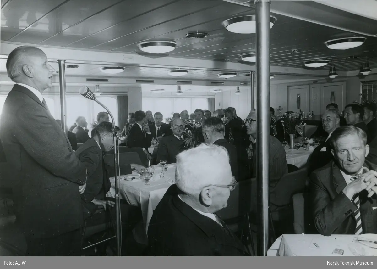 Mann holder tale under prøvetur med passasjerskipet M/S Nordnorge, B/N 550 i Oslofjorden 5. juni 1964. Skipet ble levert av Akers Mek. Verksted til Ofotens Dampskipsselskap under denne prøveturen.