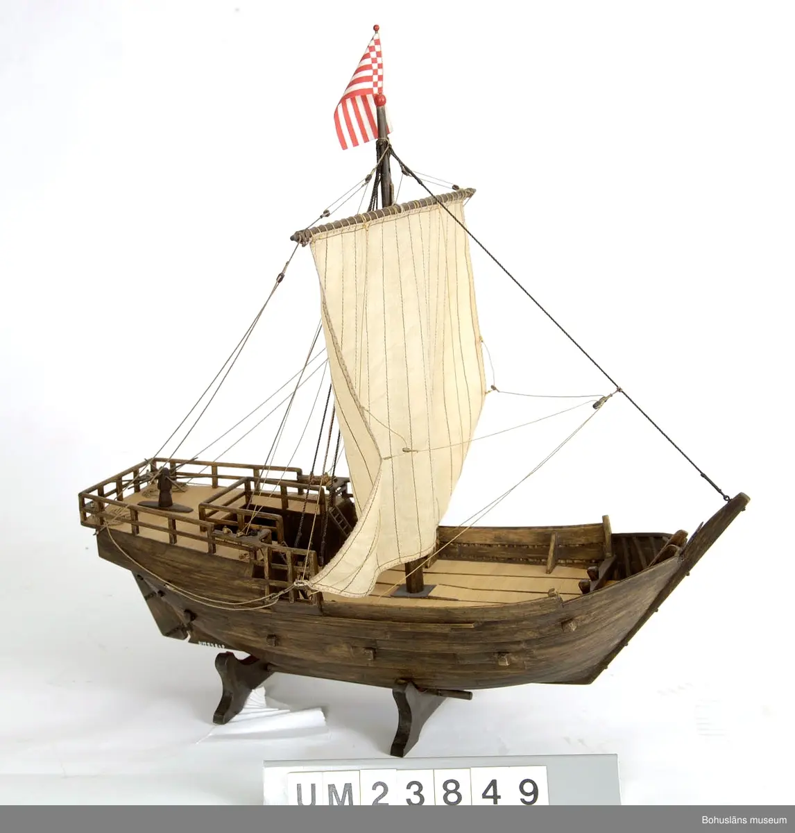 Föremålet visas i basutställningen Kustland, Bohusläns museum, Uddevalla.

Modell av medeltida kogg i skala 1:50.
Förebilden är den kogg, daterad 1380, som togs upp i Bremens hamn 1962 och som visas på Deutsches Schiffahrtsmuseum i Bremerhaven.

Modellen är tillverkad av den polske modellbåtbyggaren Jerzy Litwin, antikvarie på museiavdelningen, skeppsbyggnadsavdelningen på Centralne Muzeum Morskie i Gdansk. Han är specialicerad på medeltida skeppskonstruktioner.

Modellen är tillverkad till sommarutställningen 1988 på Bohusläns museum som presenterade Mollösundskoggen från 1300-talet (UM023101).

Litteratur:
Klaus-Peter Kiedel, Uwe Schnall, "Die Hanse-Kogge von 1380", Geschichte, Fund, Bergung, Wiederaufbau, Konservierung, Förderverein Deutsches Schiffahrtsmuseum, Bremerhaven, 2. Auflage (1989).

Se Bilagepärmen UM23849 för korrespondens.