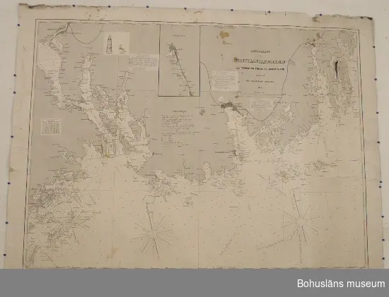 Rullat sjökort av kraftigt papper med tryck på ena sidan och blå baksida. "Specialkart over Kristianiafjorden fra Tönsberg Tönde til Jomfruland utgivet af Den Geografiske Opmaaling. 1870" i skala 1:50 000. Stämplad: "Kartet rettet til 1886. Norges geogr. opmaaling Christiania". Påklistrad pappersetikett på baksidan: J. W. Cappelens Boghandel. Krikegaden No. 15 Christiania. Kart No. 32. (Överstruket och ändrat med blyerts till "25") Pris Kr. 2,75."
Revor,  slitna och trasiga kanter, fukt- och mögelfläckar.

Sjökorten har använts inom fraktfarten i det handelshus som drevs på köpmanshuset på Herrön i Tjörn kn. Här bedrevs flera olika verksamheter under 1800- och 1900 talet. Ryggraden var fraktfart på England och sillsalteri. Man drev också handelshus och hade en skeppshandel och dagligvaraffär. Under en period på 1930-talet torkade man lutfisk. Under slutet av 1800-talet byggdes också ett badhus för sommargäster.

För ytterligare information om förvärvet, se UM27621.