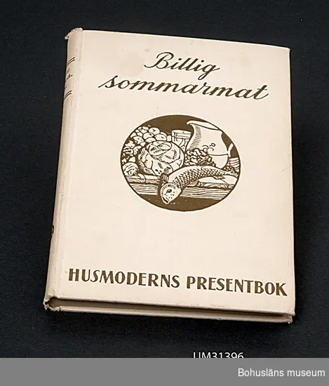 Bok; Husmoderns presentbok "Billig sommarmat", 1934. Vitt linneklotband med guldtryck.
Text på smutstitelsidan:
PRAKTISKT HANDBOK I ALLT, STORT SOM
SMÅTT, SOM RÖR SOMMARMATSEDELN
I STADEN OCH PÅ LANDET
Åhlén & Åkerlunds Boktryckeri 1934.
Ur Praktiskt företal:
Kära husmoder!
Låt sommaren så vitt som möjligt bli en vilans tid, förenkla därför hushållsmaskineriet. Duka med färgglada dukar, de verka längre fräscha än vita och se dessutom så inbjudande ut! Komma gäster så låt dem nöja sig med papperservetter. För att spara disk så servera, när ni kan, rätten i det kärl, vari den lagats. Det finns så många prydliga eldfasta kärl nu för tiden. Och det är så modernt att duka lite rustikt. 
Ur innehållsförteckningen:
Hur man lagar rätter i gelé
Vad kan man laga av sur mjölk?
Enrättsmiddagar
Sommarens bjudningar
Brått och gott
Rester
Allt om svamp
Weekend med ett primuskök
Konservering av bär, frukt och grönsaker
Billigt sommarbak

Judit Abrahamsson använde denna bok i sommarstugan.
Givarens mormor var mycket duktig på att laga mat, "men mamma var inte lika bra".

Föremålet har använts av familjen Abrahamsson i deras sommarstuga i Sundsandvik, byggd 1939.
För ytterligare upplysningar om förvärvet, se UM031385.