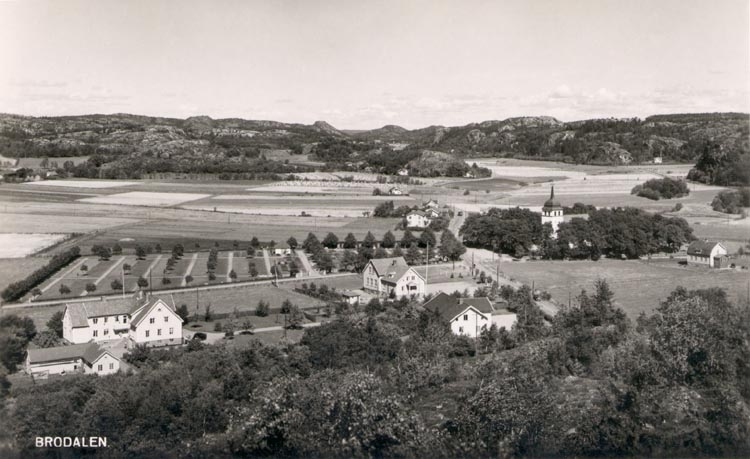 Tryckt text på kortet: "BRODALEN"
Noterat på kortet: "BRODALEN BRO SN. STÅNGENÄS(ET) 15 Juli 1955".
"UTSIKT NORDOST LÄNGS VÄGEN LYSEKIL - GLÄBORG. DEN RAKA VÄGEN TILL V. GÅR TILL VRÅNGEBÄCK. BRO KA. TILL H. I MITTPLANET".
"BROPELAREN STÅR UNGEFÄR HÄR, markerad med en ruta bortanför kyrkan".
"ENL. HOLMBERG UPPL. 2 I : 220 FINNS GRANATER I BRO SN.