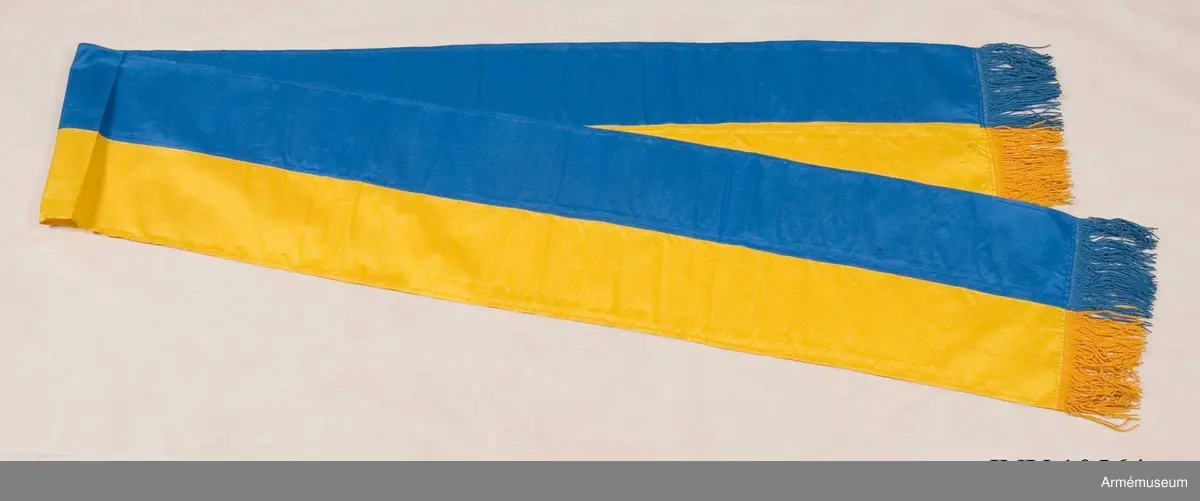 Grupp B I.

Duk av blått och gult siden typ örlogsflagga. Fodral av mörkt blått ylle. Spetsen med Gustav V:s namnchiffer.

Samhörande fodral, spets, kravatt.