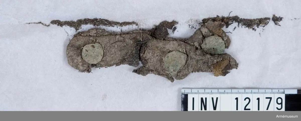 Grupp C I.
Dräktfragment med knappar. Jordfynd 1959, Blidö Furusund Tullåkern.