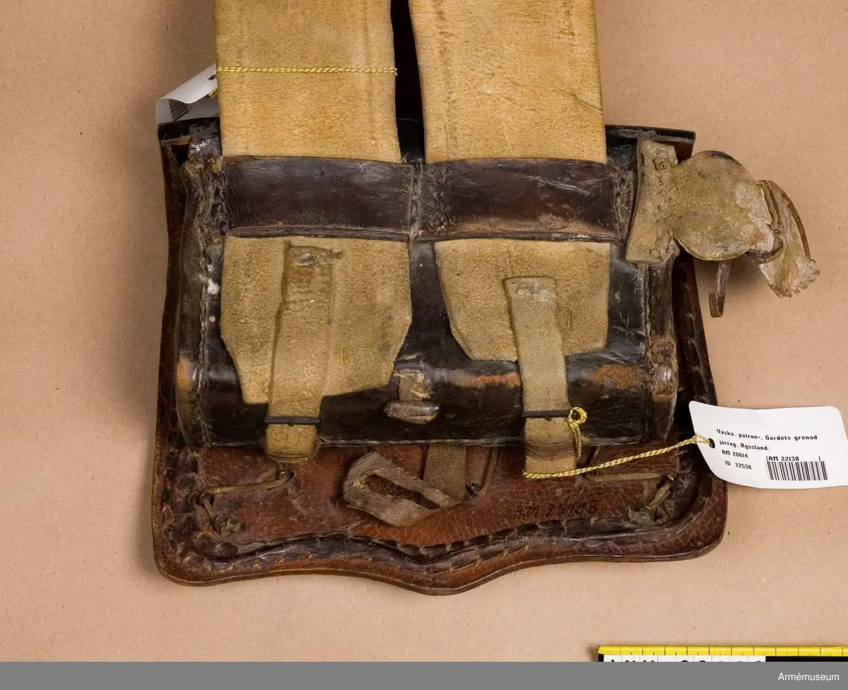 För Gardets grenadjärer vid Gardets infanteri, Ryssland. 1802.
LOCK av tjockt, svart lackerat läder, fastsytt vid väskan. På locket en rund mässingsbricka med ingraverat S:t Andreas- stjärna (kännetecken på Gardets trupper). På stjärnan står Gardets paroll på ryska, se bil.; på sv. "för tro och trohet". I stjärnans mitt en dubbelörn. På väskans fyra hörn flammande granater av mässing. Öglor på baksidan av väskan är stuckna genom hål i locket och fastknutna vid det samma med en smal rem. Fastsytt runt lockets ytterkant en järntråd klädd m läder.
VÄSKA av tjockt, svart, lackerat läder. läder. Ett tunnare läderlock betecker den. På framsidan en  liten läderficka med läderlock. Fastsydda på siforna av väskans baksida två korta remmar. På väskans nedre del två spännen. Läderbiten av vitt läder med vilken patronväskan sammankopplas med sabelremmen. Läderlappen fastsydd högra baksidan till väskan. Patronväskan rymmer 30 patroner.