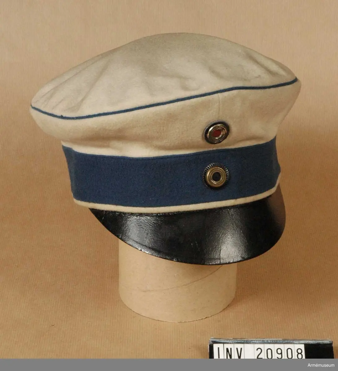 Grupp C I.
Fältmössa m/1860. Ur uniform för officer, major vid Ostpreussiska Kyrassiärregementet Nr 3 Graf Wrangel. Armékåren 1918-19.
Buren av G Hamilton.
Skärmmössa med bräm, b:45 mm, och vit passpoal längs nedre kanten samt vit kulle med blå passpoal på kullens övre kant. Kokarder: den tyska rikskokarden under kullens övre kant i färgerna svart-vitt-rött. Vit ring av nysilver. (Ringar av nysilver endast för officerare.) Skärm av svart läder.
LITT  Das Deutsche Heer, Zweiter Band, Kavalleri, Bild 69,70: Regementsuniform i färger. Bekleidungsvorschrift für offiziere und Sanitärtsoffiziere des königl, Preuss. Heeres, Berlin 1899, s 51, 52 paragraf 63. Denna skärmmössa är i detalj likadan som den i boken Geschichte des Bekleidung und Ausrüstung, Berlin 1878, sid 32 paragraf 658: Denna skärmmössa infördes 9/8 1860.Enl W Granberg.