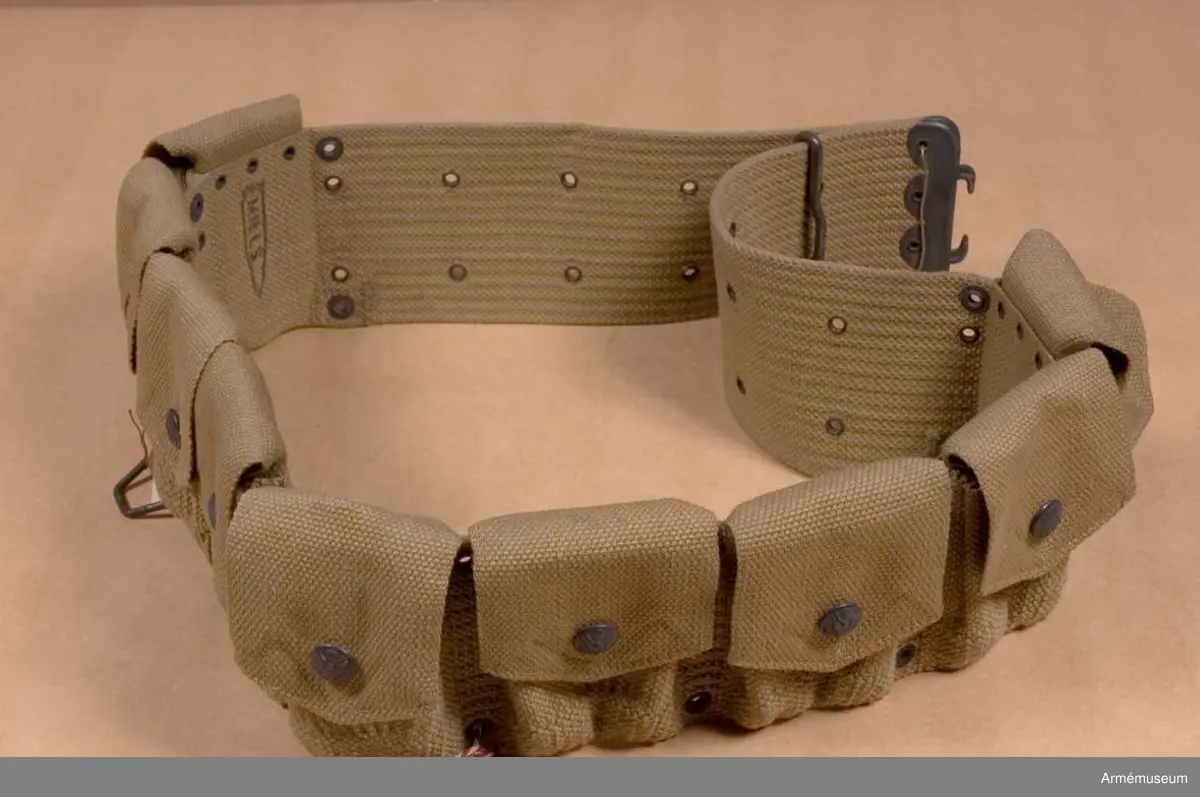 Grupp C II.
Av bomullstyg, "Webbing". Lock som stängs med knappar med det amerikanska statsvapnet, örn med sköld.
Enl Amerikanska uniformer ur Life 19 maj 1941. Sidan "Enlisted men" i "the field uniform" - soldat med lika- dant bälte och patronväskor. Sista sidan "11" två patronväskor.  Armeen album III. Die Armee der Vereinigten Staaten von Amerika. Von de Witt Clinton Falls. Morits Ruhl. Leipzig. Bilaga. Sida 5, 6: "Kadett. Felduniform" och "Uniform für kaltes Klima" med samma patronväskor. Beskrivning av kapten Granberg.