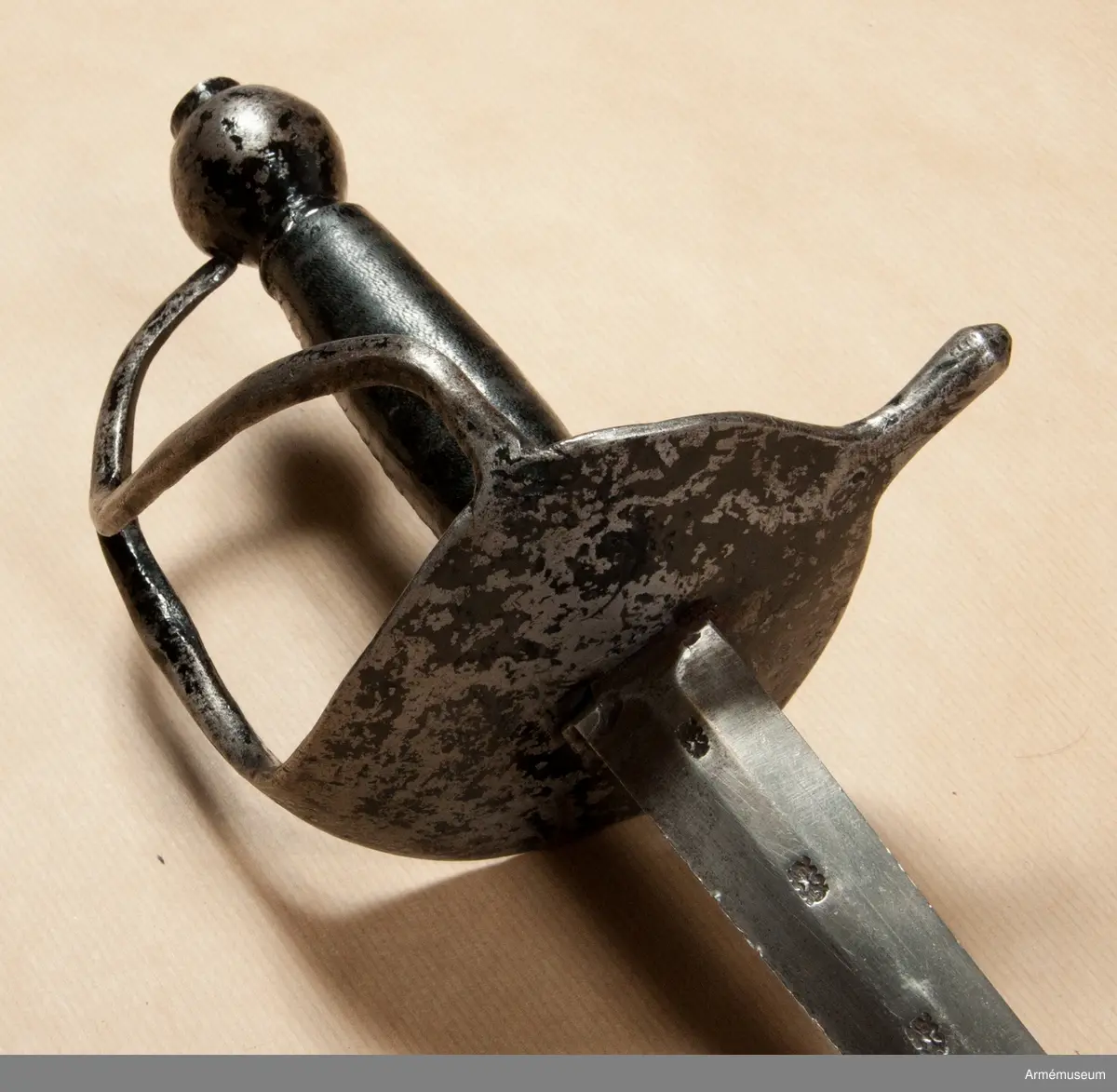 Klingan har på var sida tre stämplar och upptill på kvartsidan dessutom P-stämpel. Fästet är svärtat. Kavellindningen är av mässingstråd. Tumbygel saknas.
Värjan är ursprungligen en infanterivärja m/1685, som förkortats och vars tumbygel borttagits.