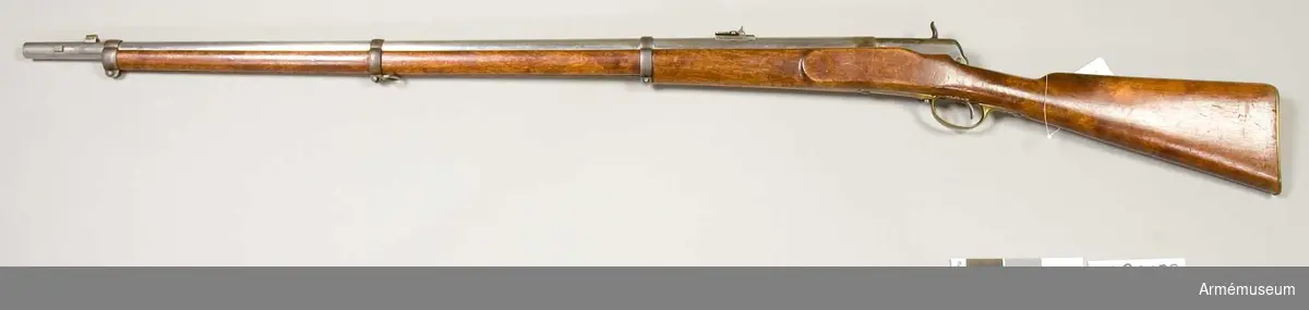 Grupp E II. 
Antal refflor: 6 st. Reffelstigning: Ett varv på 112,8 cm.

Pipan är blank och ursprungligen avsedd för ett kammarladdningsgevär m/1864 (AM 4428). Korn och bajonettklack äro lika som på sistnämda modell. Vinkelklaffsaiktet sitter 10,7 cm framför lådans främre ände. Den långa siktarmen är utbildad till ett med löpare försett remsikte, vilket är försett med siktskåror, men saknar gardering. Baktill är pipan inskruvad i framänden på en gråhärdad låda, vilken framtill är rätt djupt. Lådans bakre parti är grundare och har i botten hål för avtryckaren. Från lådans bakre ände utgår ett 7,5 cm långt svansjärn, som längst fram på översidanångt hål genombruten klack.

Mekanismen har utvecklats ur Hagströms kammarladdningsmekanism (AM 4428). Slutstycket är 10 cm långt, samt har på översidan en längsgående ränna. Längst bak på översidan en längsgående ränna. Längst bak på undersidan har det ett par parallella klackar, vilka genombrytas av ett hål och stå på ettavstånd av 1,3 cm från varandra. Dessa klackar placeras på var sin sida om den från svansenjärnets översida utgående klacken. Genom hålet i slutstyckets klackar och genom hålet i svansjärnets klack går en skruv, kring vilken slutstycket är rörligt. Litet bakom framänden går från slutstyckets undersida en kraftig klack nedåt samt litet bakåt. En annan, tunnare sådan klack går parallellt med den förstnämda omkring 1,3 cm längre bak. På högra sidan äro bägge klackarna avfilade omkring 3 mm, men den bakre klacken har  längst ned en utstående, 5 mm hög tand. I slutstyckets övre högra kant går ett 0,65 cm brett spår in till slutstyckets urborrning. Framtill börjar spåret 1,1 cm bakom slutstyckets framkant, men baktill går det ända ut i kanten. På framplanet har slutstycket ett 5 mm långt, med tätring av stål försett munstycke, vars yttre diameter är 14,5 mm. I slutstyckets urborrning är spiralfjäderlåset anbringat. Urborrningen tilltäppes baktill av en bakifrån införd, 2,8 cm lång järnpropp, vilken framtill har en 1,1 cm djup urborrning för den kring nålskaftet lindade spiralfjäderns bakre ände. Från proppens högra sida går en skena snett uppåt, vilken är inpassad i och utfyller spåret i slutstyckets övre, högra kant. Proppen fasthålles av en genom lådans högra vägg gående skruv. Tändnålen, vars fria del är 2,5 cm lång, är baktill och det av mässing tillverkade nålskaftet är framtill inpassat i resp. bak- och framänden av en 3,3 cm lång, med hel- och halvspännshak försedd järncylinder, vilken passar i och kan glida i slutstyckets urborrning. Baktill är denna cylinder urborrad till ett djup av 2,7 cm, i vilken urborrning spiralfjäderns främre ände anbringats. Från cylinderns högra sida går en klack, vilken är lika lång som sylindern, snett uppåt åt höger och är inpassad  i spåret på slutstyckets övre, högra kant. En 8,5 cm lång skena,  som ligger längs utsidan av slutstyckets övre högra kant, är  gjord i ett stycke med sistnämda klack. En 1,2 cm lång,  horisontalt ställd tapp utgår från skenan 3,1 cm bakom framänden och omkring 2 cm framför bakänden finnes ett framtill krusat tumgrepp. Nålen går ut genom ett hål i munstyckets centrum. Nålrörets bakre mynning omgives av en läderpackning. Litet framför slutstyckets bakre klackar sticker stångens bakände ut genom slutstyckets undersida. Stångfjädern är med en skruv fäst vid slutstyckets undersida framför stången och trycker den sistnämda uppåt. Avtryckarens övre, kloliknande del ligger an emot stångändens översida och pressar vid avfyrning stångänden nedåt. På stockens högra sida är ett låsblecksliknande beslag fastgjort med tre skruvar. Framtill har detta beslag tre "hävarmstappar".