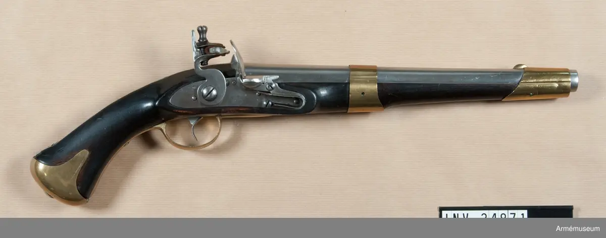Flankörpistol m/1807 av Helvigs konstruktion, med flintlås. Kaliber: nominal 16 mm, verklig 16,55 mm. PIPAN är rund. Svansskruven har baktill en hake, som är inpassad i ett hål på det vid stocken fästa svansjärnet. Ett båtformigt mässingskorn sitter 4,1 cm bakom mynningen. På svansjärnet sitter ett högt ståndsikte. Svanskruvsjänet fasthålles av en uppifrån isatt korsskruv. På pipans översidan monogram av I T samt G B och en otydlig stämpel. På vänstra sidan numret 46 och på undersidan ett R. Loppet är slätborrat.

LÅSET har platt bleck, fängpannearm och eldskärm. Studeln har en egendomlig, kantig form. Slag- och eldstålsfjädrarna är så krökta att den främre låsskruven går inom deras bukter. På bleckets insida monogram av I M.

STOCK av björk och svart. På V sidan bakom sidblecket inslaget nummer 46 och årtalet 1811. Till V om varbygelns främre arm står nummer 29.

BESLAG av mässing. Kolvkappan har rätt korta, avrundade flikar och är hoptryckt från sidorna. Den fasthålles av en skruv i centrum. Varbygelns bakre arm går ned till kolvkappan och fasthålles av en skruv. Den korta främre varbygelsarmen har docka. Sidblecket är platt och böjt i rät vinkel. Pipan fasthålles av två band, vilka kvarhållas av stift. Näsbandet är ganska långt, litet utskuret för kornet och har nedtill en kort, bakåtgående spets. Det nedre bandet har en kort, framåtriktad spets. På sidbleckets utsida numret 46, G.S, PLB, otydlig kronstämpel och en stämpel med tre bokstäver, av vilka den första är oläslig och de två andra P S. På insidan siffran 5. På kolvkappans vänsta flik en understruken tvåa och under detta "21".Pistolen har "anslagsjärn" (se AM 34897) och är sålunda avsedd för löskolv.

Ett par pistoler m/1807 bestå av en blänkare- eller flankörpistol, lika den ovan beskrivna, samt en studsarepistol (se AM 34897). Till varje pistolpar hörde en löskolv, även kallad "löst anslag" och en lös järnladdstock. Löskolven och laddstocken passa till bägge pistolerna.