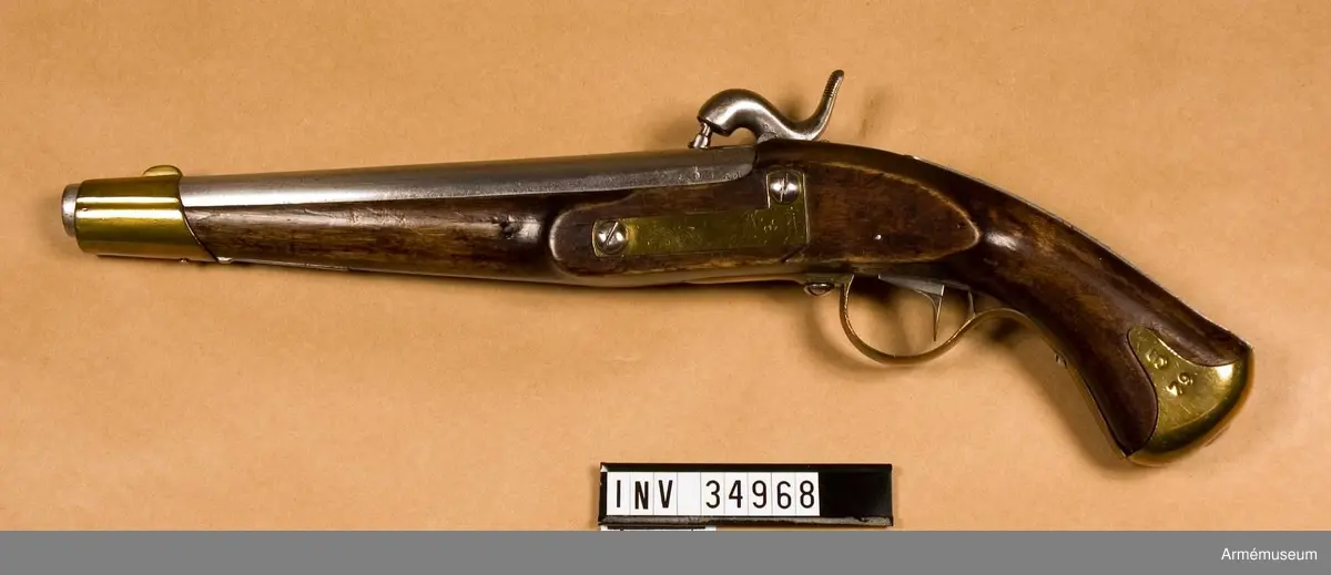 Tappstudsarpistol med slaglås.
Spetskulan l:23.16 mm, d:15,55 mm, vikt 25,88 gram. Krutladdningens vikt 3,31 gram. Fyra räfflor. Räffelstigning: Ett halvt varv på piplängden. Pistolen är ursprungligen en i Carl gustafs stads gevärsfaktori 1837 tillverkad studsarepistol med flintlås där låset 1850 ändrats till slaglås och pipan försetts med tapp enligt en 1849 fastställd förändringsmodell. Det gamla fänghålet är tärnat och en utstående järntapp anger dess plats. Knallhattstappen är inskruvad direkt i pipan litet till höger om siktlinje. På pipans vänstra platt står 3 och AM, på pipans udersida 1837, EH, P2, IF. 663 och  1850.

Den vid ändringen tillkomna slaglåshanen är kullrig och svängd ganska mycket in över pipan. Halvspännet är högt, men i hakspänn står hanens slagyta blott obetydlig över knalhattsstappen. På låsbleckets utsida står krönt C och 633, på insidan ÅG, 1837 och AM. På stockens vänstra sida bakom sidblecket är inslaget numret 633. På sidbleckets och näsbandets insida är inslaget ett B och på kolvkappans vänstra flik stå 5 och 70. På de skruvar som fasthåller anslagsjärnet, är numret 21 inslaget.