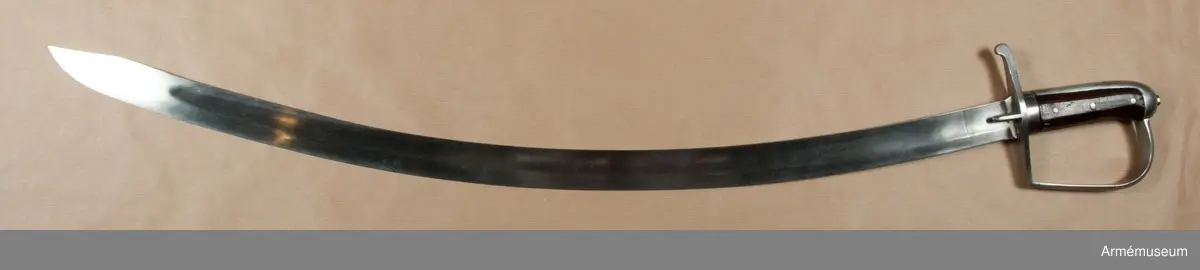 Klingbredd upptill: 36 mm. Klingan är krökt samt på större delen av sin längd eneggad och skålslipad. Udden sitter nära nog i klingans mittlinje. På en längd av omkr 31 cm från udden har klingan egg även på rygg-sidan. Upptill på yttersidan står "ZETTERBERG" och upptill på innersidan är en stämpel med bokstäverna C. F. K. inslagen.

Fästet är av järn. Tången är bred, och vid den är på var sida en skena av mörkt trä anbringad, vilka båda skenor fasthållas av tre genomgående nitar. Nederst omgives kaveln av ett ringliknande, 1,1 cm järnbeslag. Baktill har kaveln ryggbeslag, som uppåt övergår i en låg avrundad kappa. Tångens översta del fasthålles av en påskruvad, åttkantig liten mutter, som sitter ovanpå kappan.
Parerstången är rak och har fyrsidigt tvärsnitt. Baktill avslutas den av en nedböjd knapp. Upptill på parerstångens bakre arm är siffran 8 inslagen. Ett par små styrskenor, som har avfasade kanter och avrundade ändar, utgår från undersidan av parerstångens mitt.Från parerstångens främre ände utgår hanbygeln i tvär vinkel men går ej rakt uppåt utan snett framåt. Den har på framsidan snedfasade kanter. Handbygelns övre ände är instucken under kappans främre kant.