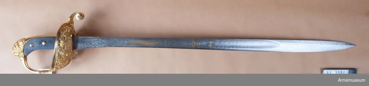 Grupp D II
Klingan, bredd upptill: 36 mm, är damaskerad och har samma form som på officersabel m/1852, d.v.s. klingans största bredd ligger en bit, i detta fall ungefär 22 cm ovanför udden. Till större delen av sin längd är klingan eneggad och svagt skålslipad, men där den har sin största  bredd får den ryggar och blir tveeggad. På yttersidan finns inskriften "Fäderneslandet", svenska riksvapnet och nordstjärnan i strålglans, men på inersidan inskriften "Konungen", allt i etsat och förgyllt arbete. Inskrifterna är som vanligt omgivna av ornamentsramar. Längst upp på insidan står "JOH, SVENGREN, ESKILSTUNA". Fästet är av kraftigt förgylld mässing. Kaveln är klädd med svärtat fickskinn och genom den gå tre nitar med förgylld huvud. På kavelns yttersida sitter Karl XI:s krönta namnchiffer i silver. Baktill har kaveln kannelerat ryggbeslag, som upptill övergår i en i form av ett lejonhuvud ciselerad kappa. Kring nedersta delen av kaveln och ryggbeslaget går ett med ciselerade ekblad pyrtt, omkring 12 mm. brett ringliknande beslag.Parerplåten är ovanligt stor, överallt genombruten och på nedre, men ej på övre sidan ciselerad. På yttersidan består orneringen av bladormament och en krönt, tudelad sköld med tre kronor i övre fältet och lejonet över tre strömmar i det nedre. Skölden har två lejon till sköldbärare. På innersidan finnes blad-  och blomormanent och en trofé, allt i kraftigt ciselerat arbete.Parerstång finnes endast baktill. Den är kort, bred, på mitten genombruten av ett ovalt hål, blir framåt mycket bred och är där översidan  ciselerad i form av ett treflikigt blad och på under- sidan enkelt ornerad med ciselering. Baktill är parerstången nedhöjd och så att säga sammanrullad till en bred, Cylindrikt, på sidorna med spiralornament prydd knapp. Knappens undre och främre sida är enkelt ornerade. Handbygeln är vid klingan rätt smal och bildar en sorts spång, som skiljer parerplåtens båda hälfter åt. Parerplåten slutar först ungefär på handbygelns mitt.Därefter har handbygeln rektangulärt tvärsnitt, är enkelt ornerad och genombrytes upptill av ett avlångt hål. Handbygeln går in i kappan i lejonhuvudets mun.