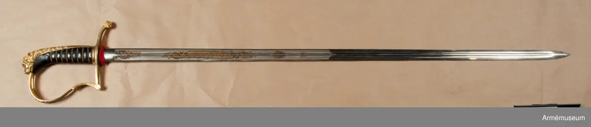 Klingbredd upptill 222 mm. Sabeln är fullkomligt AM 39928 men klingan är kortare. Den officiella längden på klingor m/1899 är 80 cm. Vid vapnet är fästat en fastställningslapp.