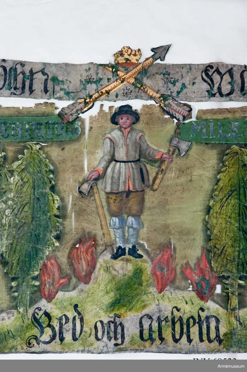 Helt bemålad duk på siden. Troligen från Stora nordiska kriget. Två korslagda pilar krönt med öppen krona (Det vill säga Landskapet Dalarnas vapenbild). En bergsman stående på en sten med fyra flammor omkring. En yxa i vardera handen. Omkring skog. Fragment. Text Överst: GRANGIERDZ SOCHN WÄSTRA COMPAGNIET. Under till vänster FRUCHTA GUD. Längst ner: BED OCH ARBETA. Överst i motivet: PERPETUUS MILES. 