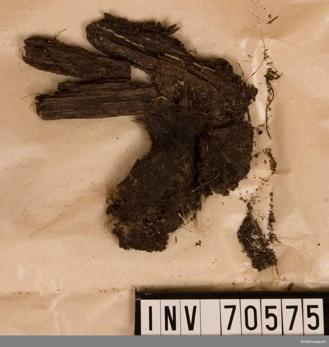 Grupp C:I. 
Funna vid grävningar sommaren 1939. Gravfynd från Sandhamn bestående av knappar och tygrester