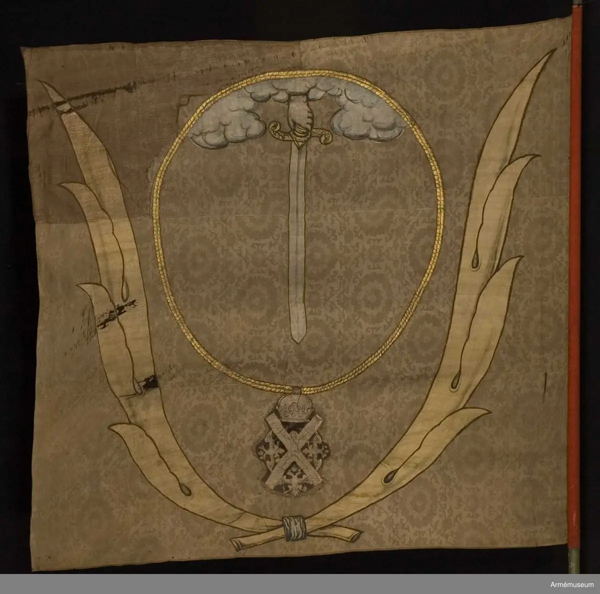 Duk av brun kinesisk sidendamast. Dekor i intarsia och målade detaljer. Motivet föreställer en hand med svärd som kommer ner ur ett moln omgivet av andreasordens kedja med dess insignier nedtill. Det hela omgivet av nedtill korslagda palmkvistar.
Slät, grönmålad stång. Spetsen bevarad.