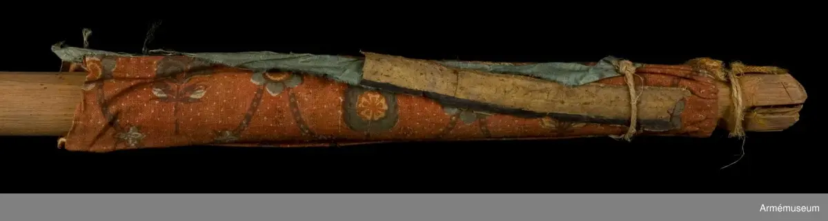 Duk av ljusblå kinesisk sidendamast med målad dekor föreställande helgonet Demetrius av Thessaloniki och slingor av blommor. Strumpa av rött linne.
