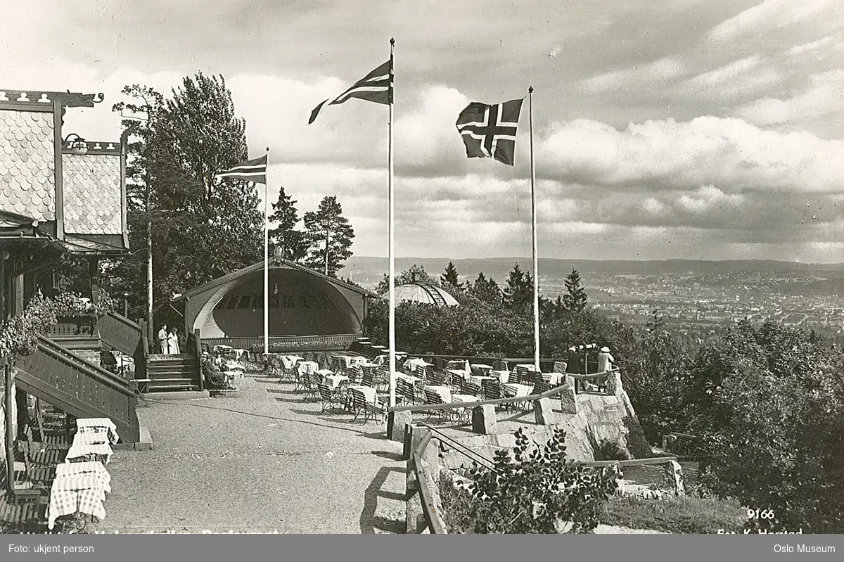 Holmenkollen restaurant, friluftsrestaurant, friluftsscene, flagg, vimpel, utsikt, skog, by