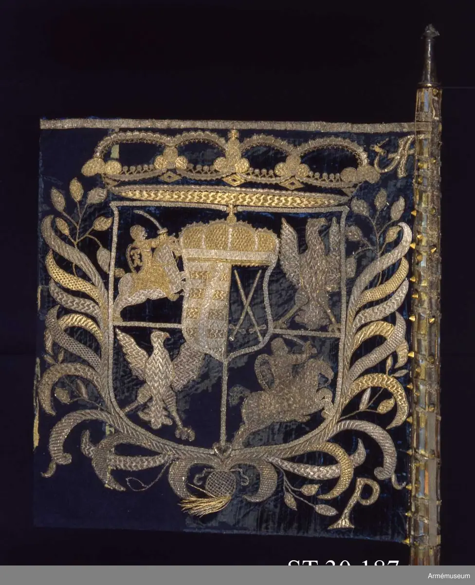 Inre och yttre sidan spegelvänt lika. Bokstäverna är dock rättvända. En i guld och silver broderad fyrdelade sköld med Polens örn i första och fjärde fältet, Litauens ryttare i andra och tredje fältet. Kluven hjärtsköld med kursvärd och Sachsens vapen, fem bjälkar. Huvudsköld och hjärtsköld krönta av stiliserade och slutna kronor. 