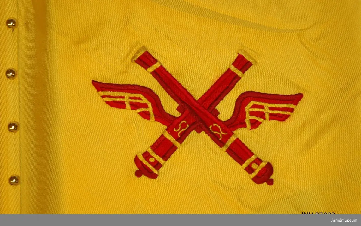 Duk av sidenkypert med landskapet Skånes vapenbild: ett med öppen blå krona krönt avslitet rött griphuvud. I övre inre hörnet två korslagda bevingade röda eldrör av äldre modell. Detta är ett traditionsarv från Skånska luftvärnskåren, Lv4.

Motivet är huvudsakligen utfört i maskinbroderi och intarsia. Vissa detaljer är handbroderade såsom hörnmotivet, näsborren, en del av ögat samt de utskjutande delarna på ömse sidor om kronan. Duken är maskinfållad med sick-sack och raksöm. Triangelformade förstärkningar i övre och nedre stångsidan.

Vitmålad, delbar fanstång. Duken fäst med släta tennlickor. Doppsko av guldfärgad plast, troligen ej ursprunglig. Spets med Carl XVI Gustafs monogram. På holket graverat: "Södra skånska regementet och Södra skånska brigaden 1998".
 
KT 2012-03-06