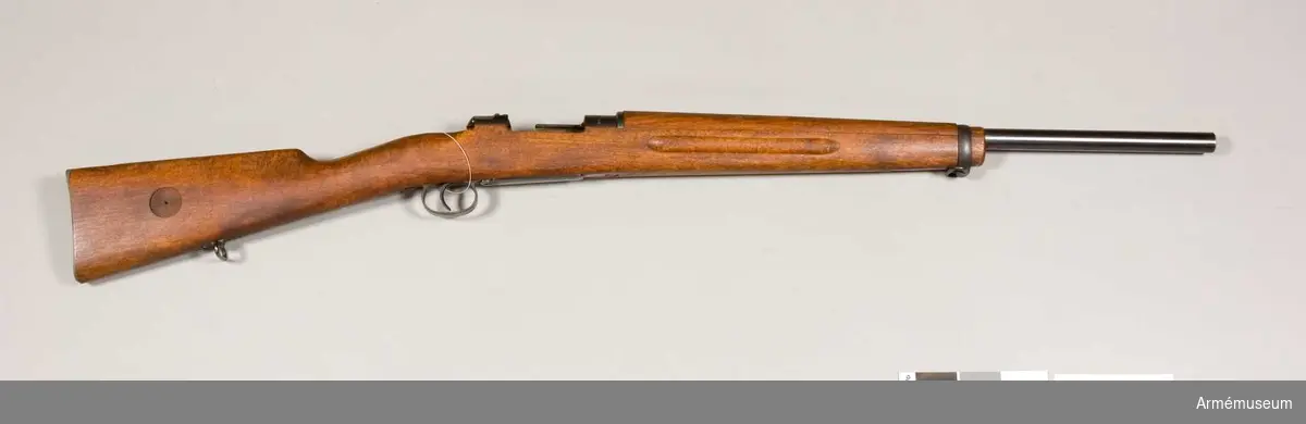 Grupp  E II f
Gevär. 7,9 mm. Geväret är kamrat för svenska 8 mm kulsprutepatroner m/1932 samt har ovanligt tjock, 60 cm lång pipa. I övrigt liknar vapnet AM.022336, men har aldrig haft några siktmedel. Geväret torde ha varit avsett för ammunitionsprovning. På lådans vänstra sida står 29/34 MAX och på hävarmsknappen 26/34. På flertalet av vapnets övriga delar är numret 26 inslaget.Se även AM.030519.
Tnr 27/34, 1932. ej sls.